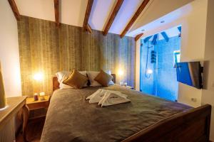 a bedroom with a large bed with a tv on it at Woodland Resort in Kragujevac
