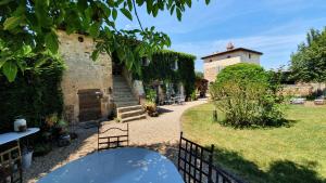 a garden with a building and a table in front of it at Le Clos Goëlle in Moissat