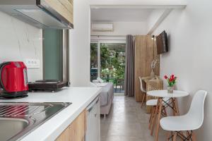 cocina con fregadero y mesa con sillas en Antonis apartments en Kalamaki