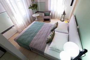 a bedroom with a bed and a chair in a room at Magnolia - Apartment in Kalamata in Kalamata