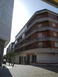 a large brick building on a city street at Céntrico, amplio y bonito apartamento en Cambados in Cambados