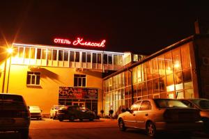 un edificio con coches estacionados en un estacionamiento por la noche en Classic Hotel, en Pyatigorsk