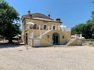 ein großes gelbes Haus mit Treppen, die zu ihm führen in der Unterkunft La quercia B&B in Abbateggio