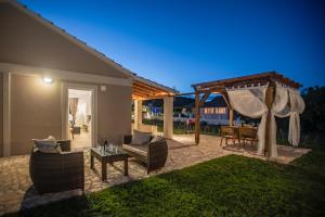 taras z altaną, stołem i krzesłami w obiekcie Villa Veneto Luxury holidays w mieście Melíssia