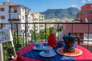 una mesa con tazas y un jarrón en el balcón en Coast & Coast | Apartments, en Piano di Sorrento