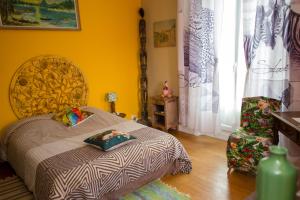 ein Schlafzimmer mit einem Bett in einem gelben Zimmer in der Unterkunft Le Madrigal in Mamers