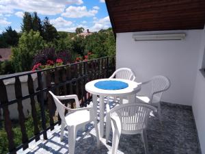 a patio with a table and chairs on a balcony at VIL'LAGUNA Apartment with view of Balaton in Zánka
