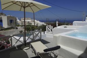 un patio avec un parasol et des chaises et une piscine dans l'établissement Oia, Finikia Cave House, à Oia