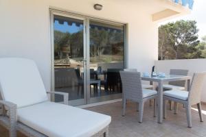 a dining room with a table and chairs on a patio at Apartamentos Catalina in Es Pujols