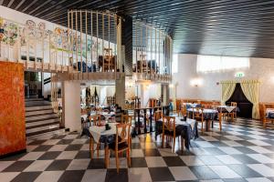 切爾維尼亞諾德爾夫留的住宿－Hotel Villa Strassoldo "Ex Attianese Hotel Restaurant"，一间带桌椅和天花板的餐厅