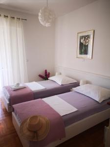 two beds in a room with white walls at Apartments Prosperina Hvar in Hvar