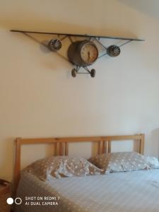 a shelf above a bed with a clock on the wall at Aéroport chambre ,au calme in Bouguenais