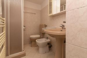 biała łazienka z toaletą i umywalką w obiekcie Veneziacentopercento Picenin Apartment w Wenecji