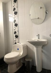 a bathroom with a toilet and a sink at B&B Cusing Wasi in Lima