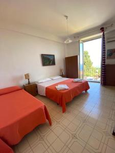 タオルミーナにあるCamere Il Leoneのベッドルーム1室(ベッド2台、大きな窓付)