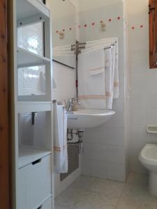 Baño blanco con lavabo y aseo en Chia Zeffiro, en Chia