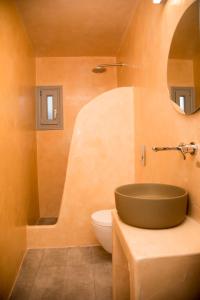La salle de bains est pourvue d'un lavabo et de toilettes. dans l'établissement Markakis Studios Fira Town, à Fira