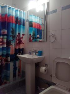 a bathroom with a sink and a shower curtain at MARGARITA'S-STUDIOS in Koufonisia