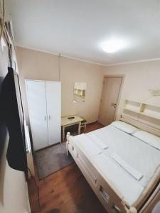 a bedroom with a large white bed and a desk at Guest House Colovic in Zlatibor