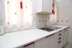 uma cozinha com armários brancos e um lavatório em Veneziacentopercento Arsenale Apartment em Veneza