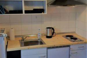 a kitchen counter with a sink and a stove at Pension Bach in Greifswald