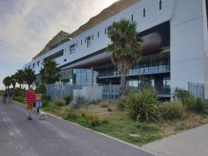 a man walking a dog down a street in front of a building at Studio Balaruc les Bains, vue sur l'étang de Thau classement 2 étoiles in Balaruc-les-Bains
