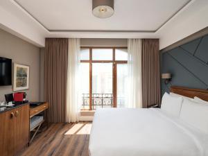 a bedroom with a large bed and a large window at Azzap Hotel Galata in Istanbul