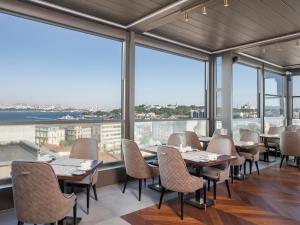 a restaurant with tables and chairs and large windows at Azzap Hotel Galata in Istanbul