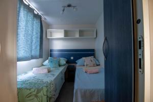 two beds in a room with blue walls and pink pillows at Mobile homes Bonaca in Srima