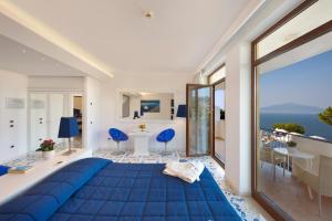a bedroom with a blue bed with a view of the ocean at Grand Hotel President in Sorrento +62 photos