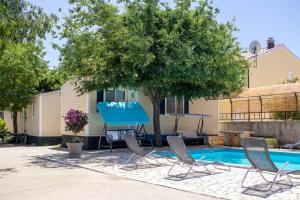 a pool with chairs and a table next to a house at Mobile homes Bonaca in Srima