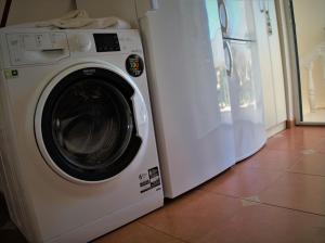 a white washing machine sitting next to a refrigerator at VILLA WITH SWIMMING POOL apartments with bathroom, kitchen, patio, private parking in Budva