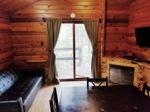 sala de estar con sofá y chimenea en Lake Texoma Camping Resort Cabin 1, en Willow Spring