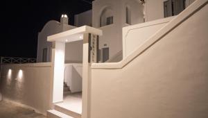 a white staircase in a building at night at Markakis Studios Fira Town in Fira