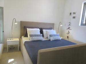 a bedroom with a bed with blue sheets and white pillows at Villa Handras-Ulivo & Mandorlo, by Amorgos Holiday Homes in Aegiali