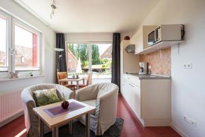 a small living room with a kitchen and a table at De Kanalkieker Apartmenthaus Meier in Berkenthin