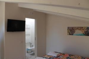 um quarto com uma cama e uma televisão na parede em A casa MIA em Ruvo di Puglia