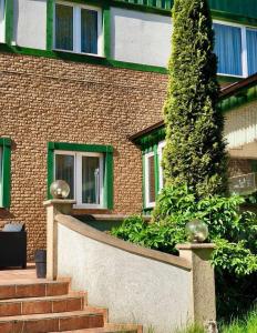 a building with a staircase in front of a tree at Folwark Nadmorska Ostoja in Mechelinki