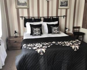 a bedroom with a large bed with black and white pillows at Folwark Nadmorska Ostoja in Mechelinki