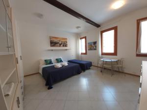 ein Schlafzimmer mit einem Bett, einem Sofa und einem Tisch in der Unterkunft Veneziacentopercento Corderie Apartment in Venedig