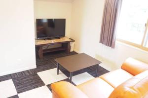 Harbour Inn & Suites 201 في نيغاتا: غرفة معيشة مع أريكة وطاولة