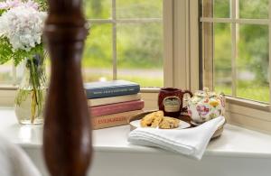 a window sill with a plate of cookies and books at 1802 House Bed & Breakfast in Kennebunkport