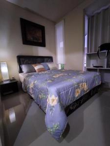 a bedroom with a large bed with a purple comforter at House at Taman Dayu in Pasuruan
