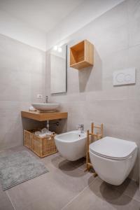 a bathroom with a white toilet and a sink at LE CORALLINE in Meta