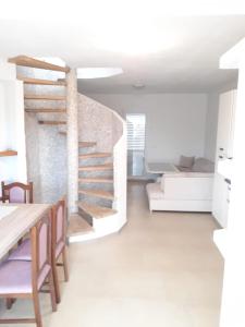 a room with a staircase and a table and chairs at Amanda C in Starigrad