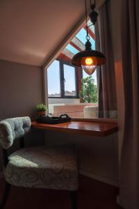 ventana en una habitación con mesa y silla en Hotel Casa da Nora, en Leiria