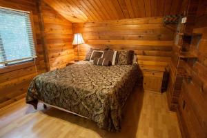 a bedroom with a bed in a wooden cabin at Lake Texoma Camping Resort Cabin 4 in Willow Spring