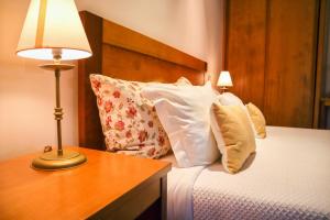 1 dormitorio con 1 cama con almohadas y lámpara en Hotel Casa da Nora, en Leiria