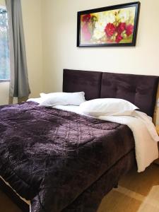 - une chambre avec un lit violet orné d'une peinture murale dans l'établissement Pousada Gianisella, à Bom Jardim da Serra