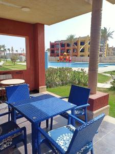 a blue table and chairs on a patio with a pool at شاليهات بورتو مطروح فيو بحر Porto Matrouh Sea View Families Only in Marsa Matruh